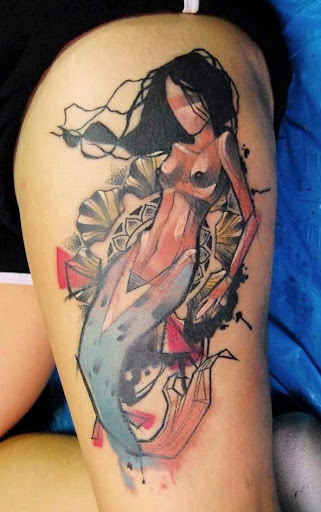 Artistic watercolor mermaid tattoo on leg.