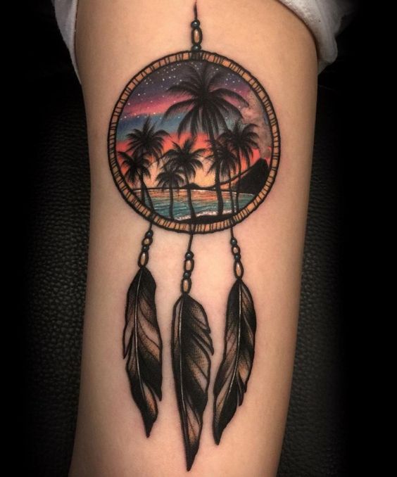 Beach view in dreamcatcher tattoo on arm.