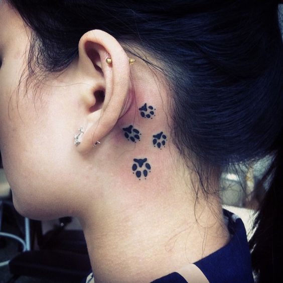 Behind the ear dog paw print tattoo.