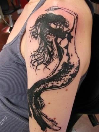 Black and white mermaid tattoo design on the shoulder of a woman.