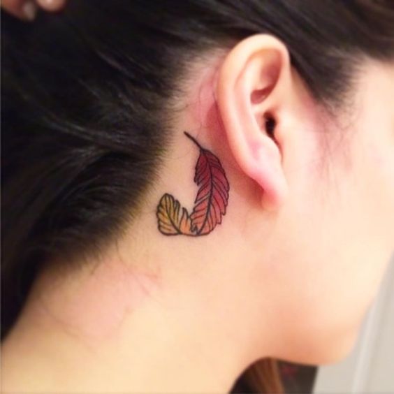 Colored behind the ear feather tattoo.