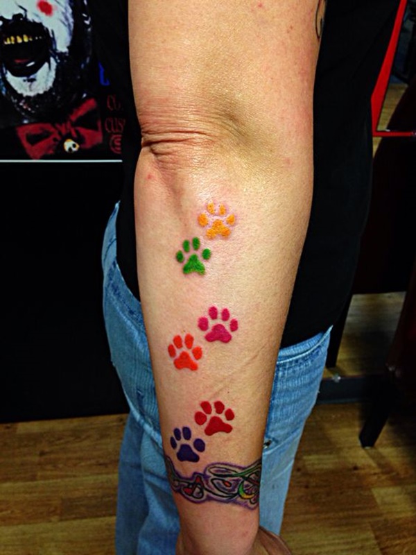 Colorful dog paw tattoo on hand.