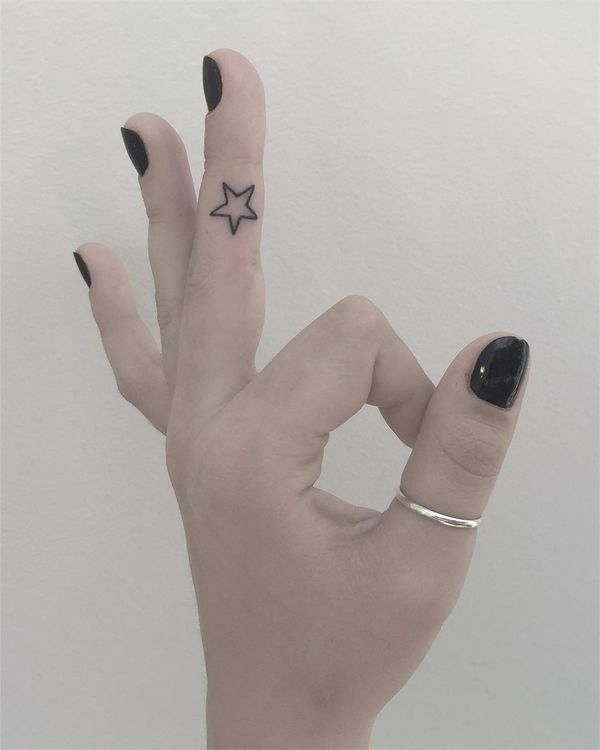 Compact finely-lined finger star tattoo.