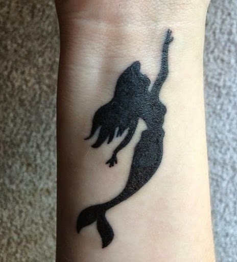 Cool black mermaid wrist tattoo.