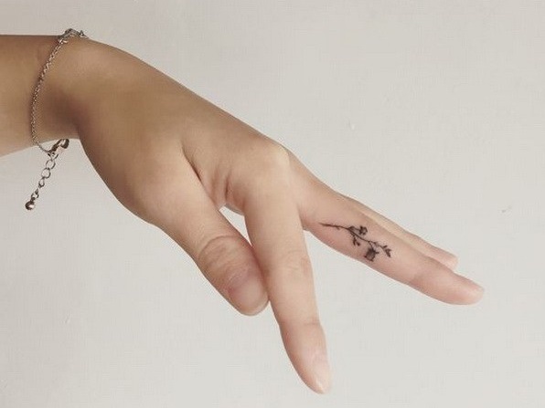 Cool tiny flower tattoo on finger.