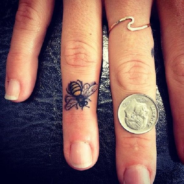 Cute little finger bee tattoo looks realistic and perfect.