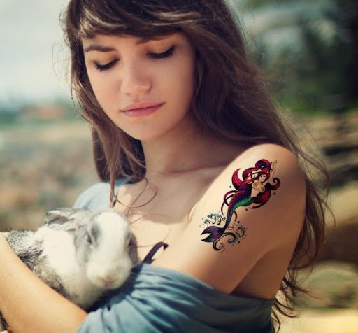 Dashing mermaid Tattoos on the shoulder of a girl.