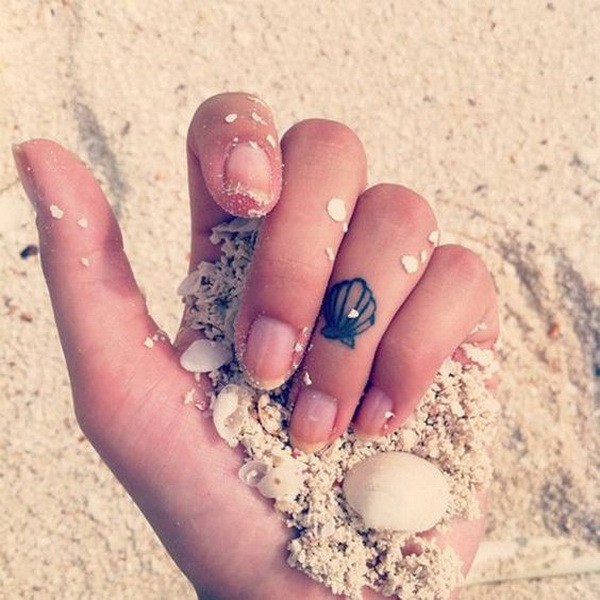 Fabulous cute seashell tattoo design on finger.