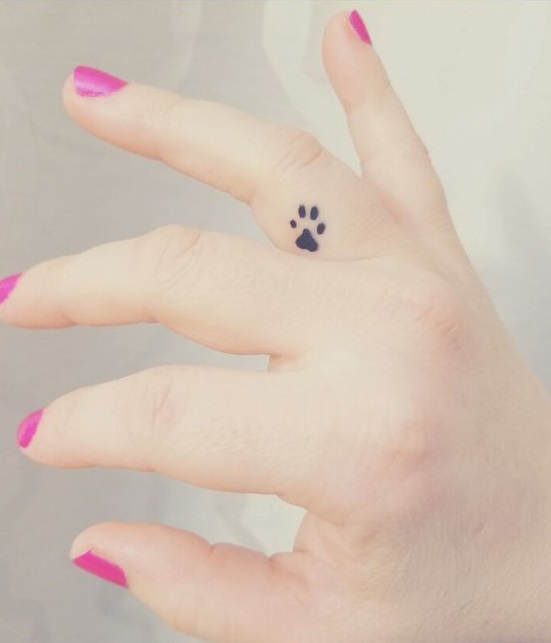 Glamorous inner finger paw print tattoo.