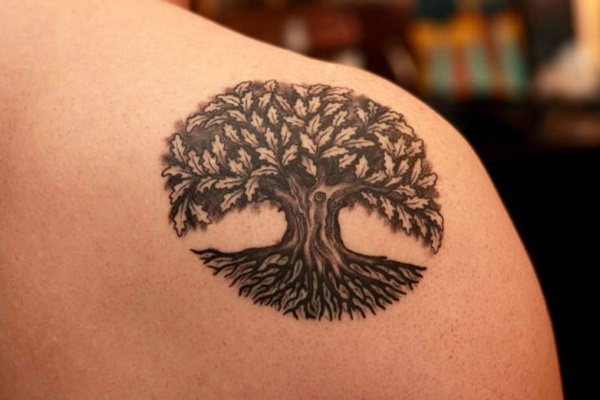 Graceful old tree tattoo with roots and leaves.
