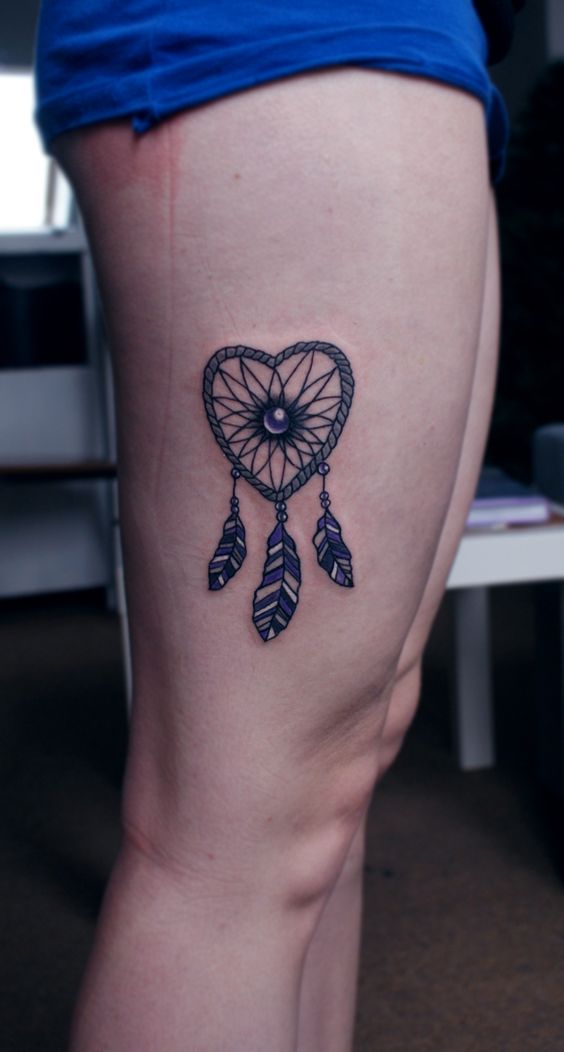 Heart dreamcatcher tattoo on thigh.