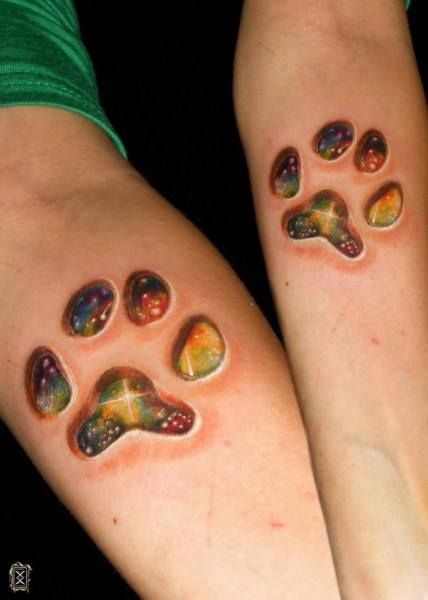 Multicolor stone paw print tattoo on both arms.