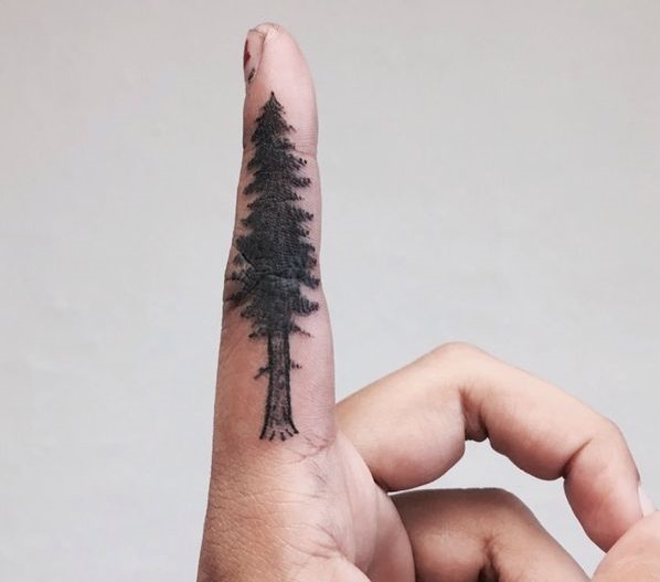 Pine tree finger tattoo in blackwork.