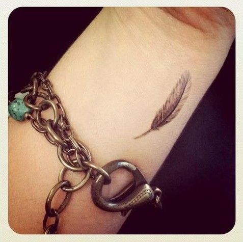 Pretty feather wrist tattoo.