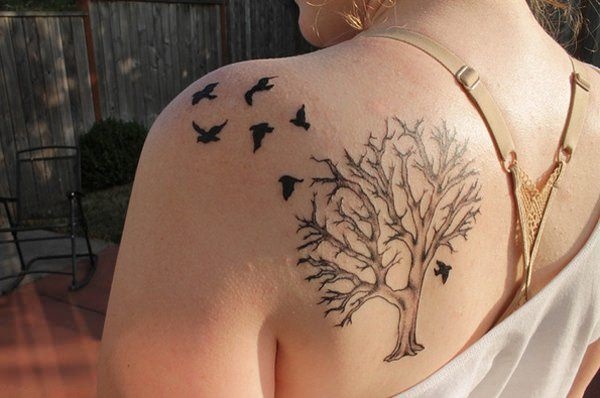 Shoulder tattoo with dead tree and birds.