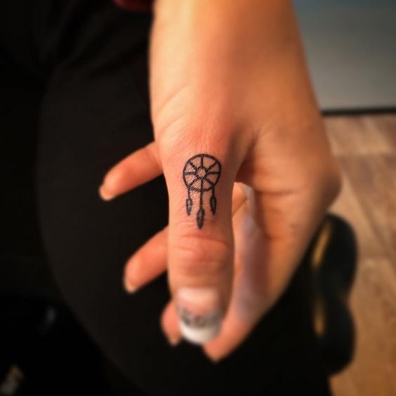 Simple dreamcatcher tattoo on thumb.