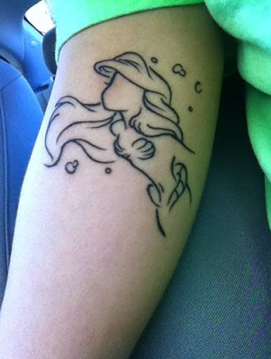 Small mermaid outline upper arm tattoo.