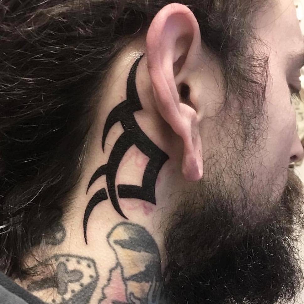 Tribal tattoo behind the ear.