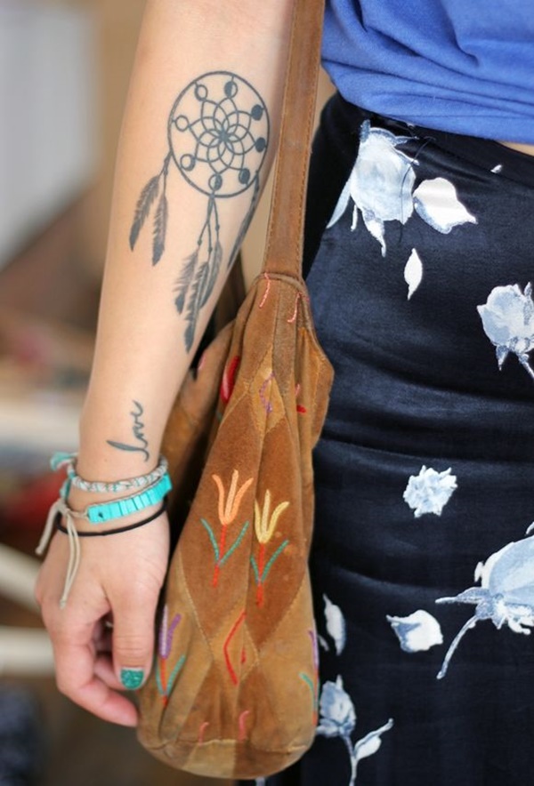Tribal theme dreamcatcher tattoo on arm.
