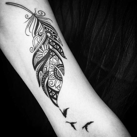 Trible feather tattoo with birds on arm.
