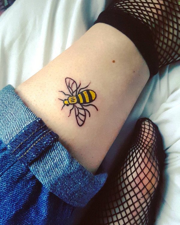 Vibrant colored bee tattoo.