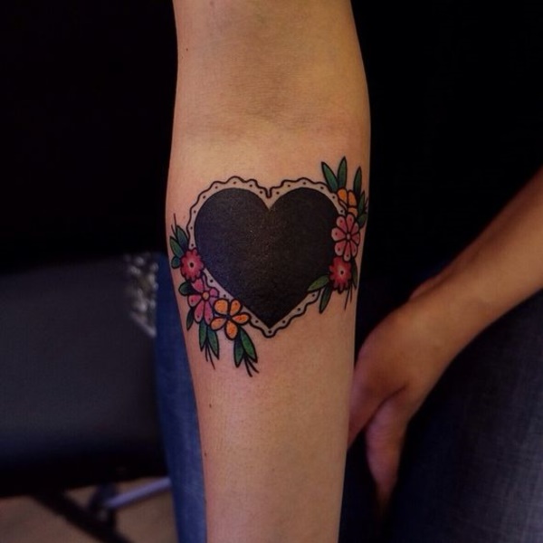 Black heart and colorful flowers creating a unique canvas on forearm.