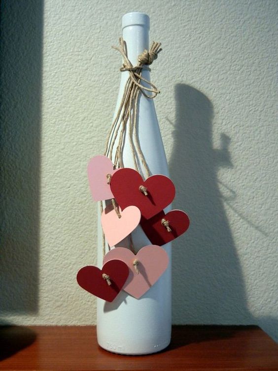 Craft paper red and pink hearts tie on the neck of bottle.