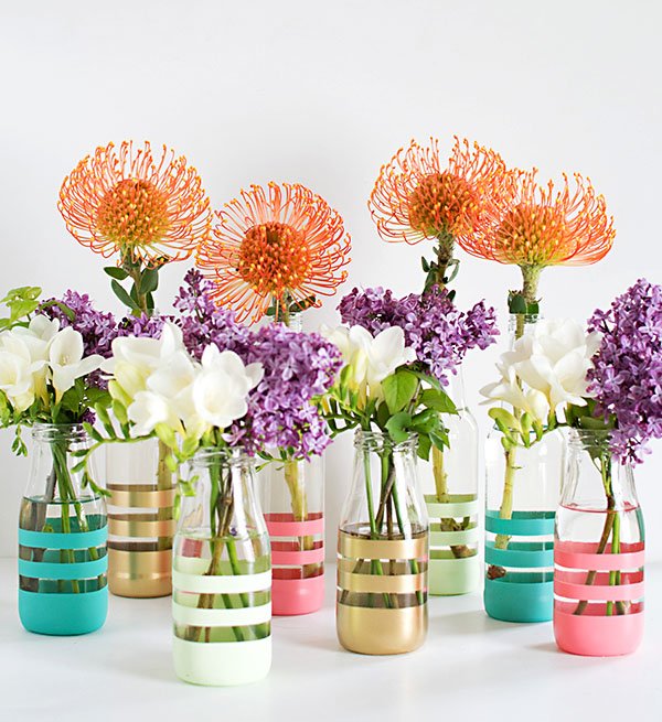 Colorful painted bottles as flower vase for Easter centerpiece.