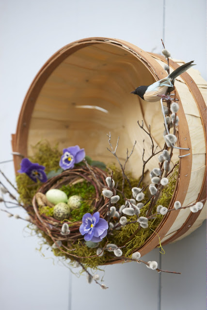 Whicker basket along with faux moss, greenery and purple petunias.