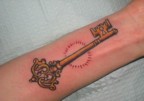 A beautiful golden key with a red sun as the tattoo design.
