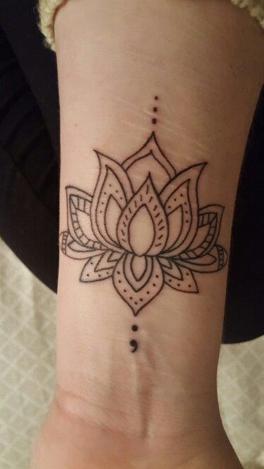 A mandala tattoo with the semicolon on an arm.