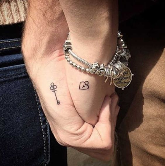 Adorable lock and key couple tattoo for hand.
