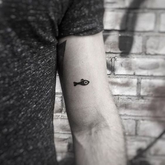Awesome black little fish tattoo.