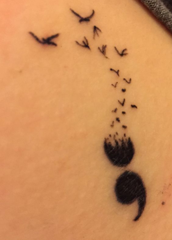 Awesome large back tattoo of a semicolon with the upper dot fading into a flock of birds.