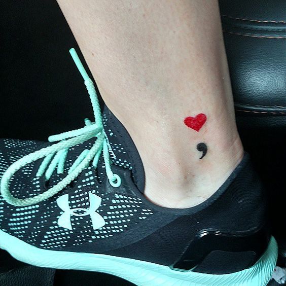Beautiful semicolon ankle tattoo with upper heart sign in red.
