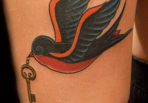 Black and orange bird holding a key.