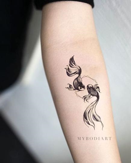Black double koi fish tattoo on arm.