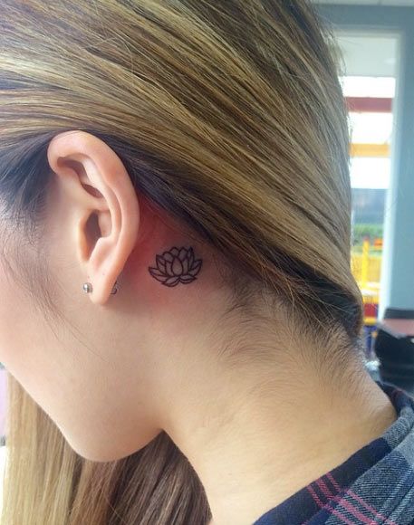 Black lotus tattoo behind the ear.