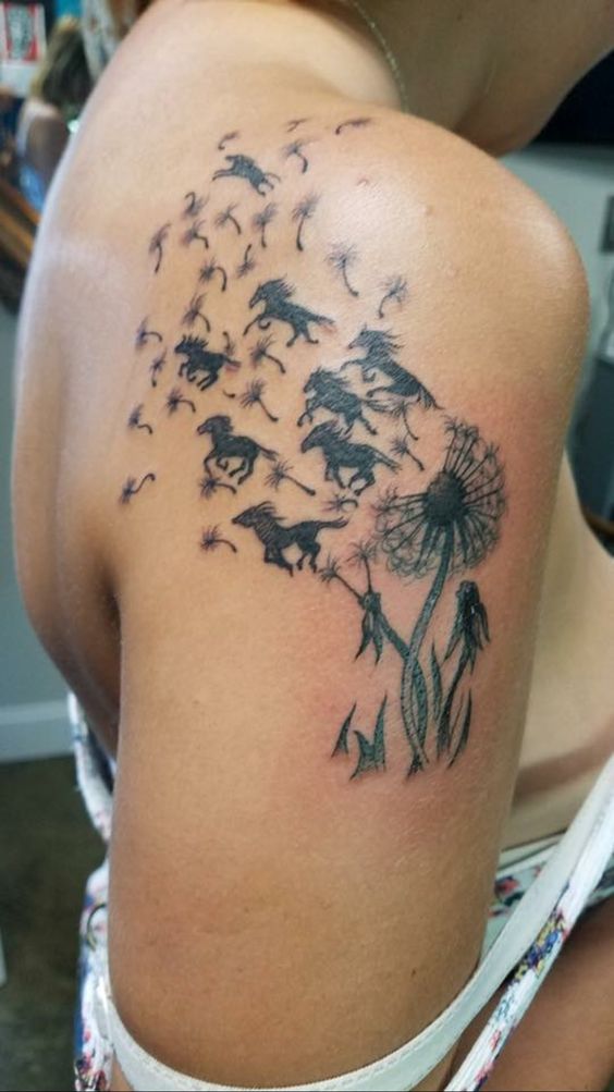 Black tattoo horses are flying away from a dandelion flower.