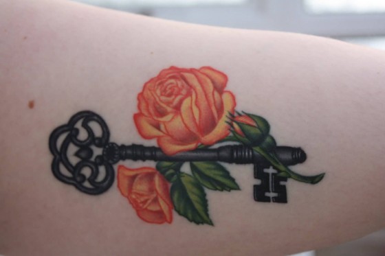 Charming orange rose with key tattoo idea.