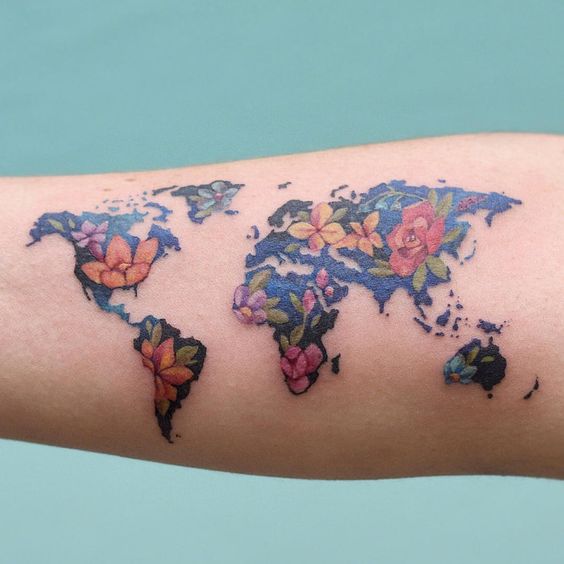 Colorful world map tattoo decorated with flowers.