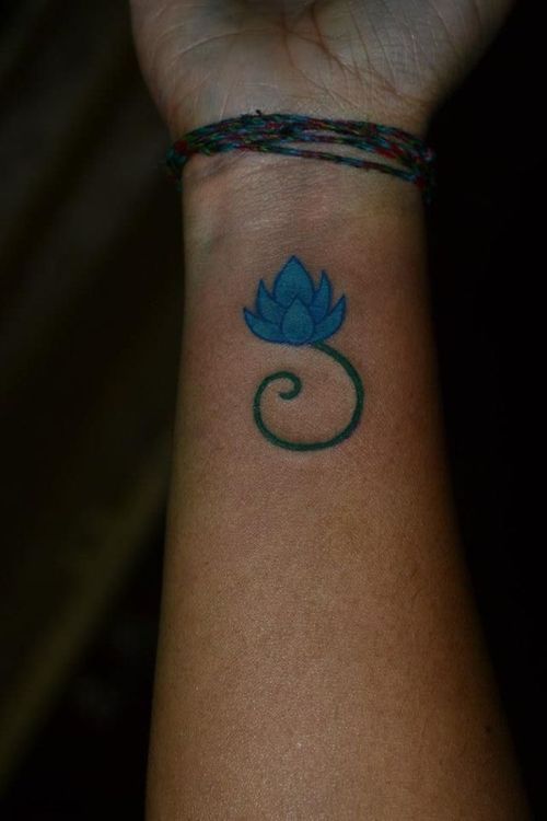 Dashing blue flower wrist tattoo idea.