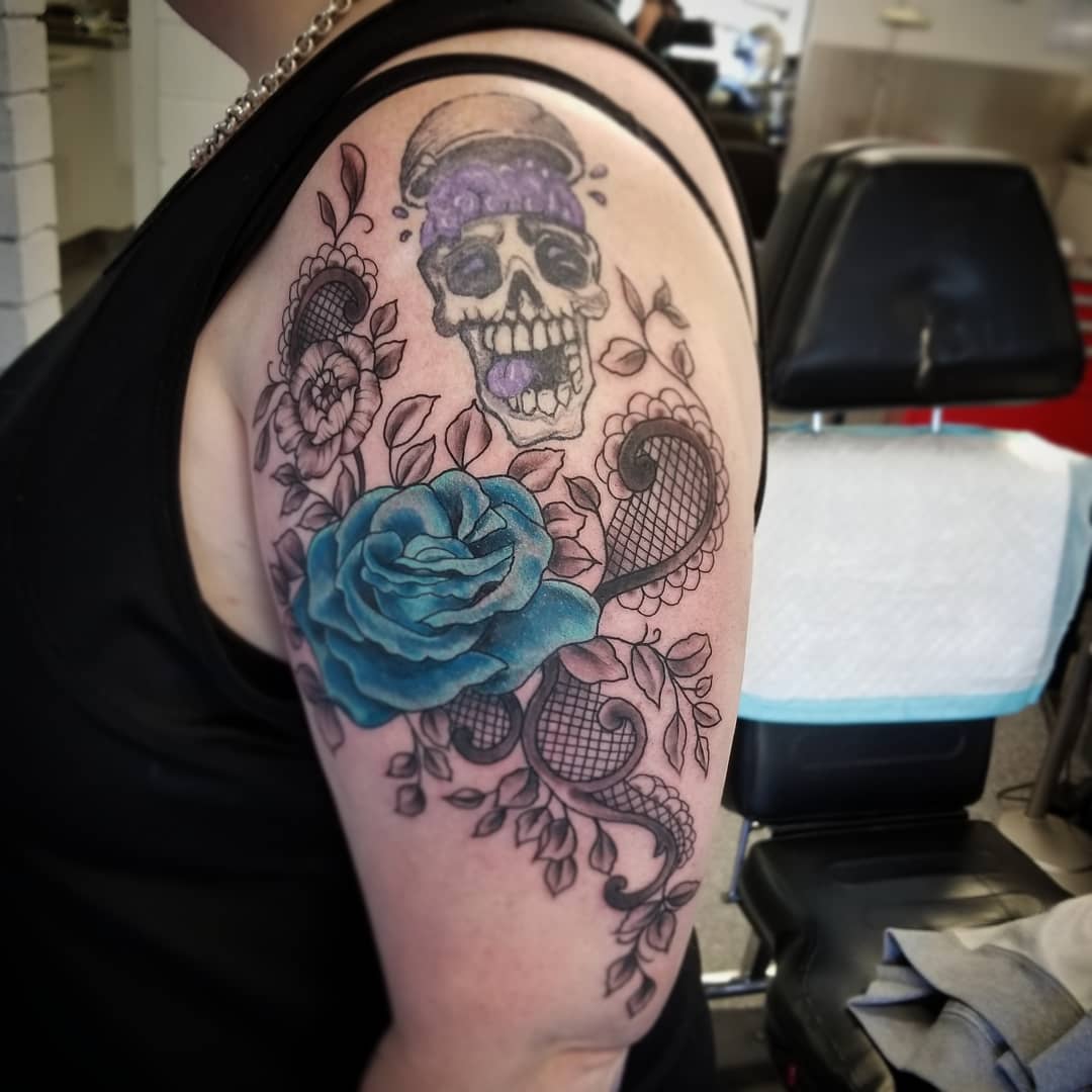 Dashing lacey rose tattoo with skull.