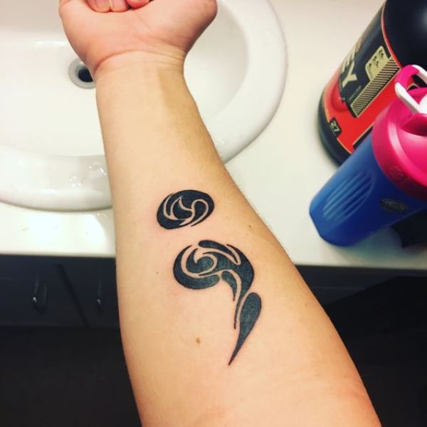 Ethnic black semicolon tattoo for inner arm.