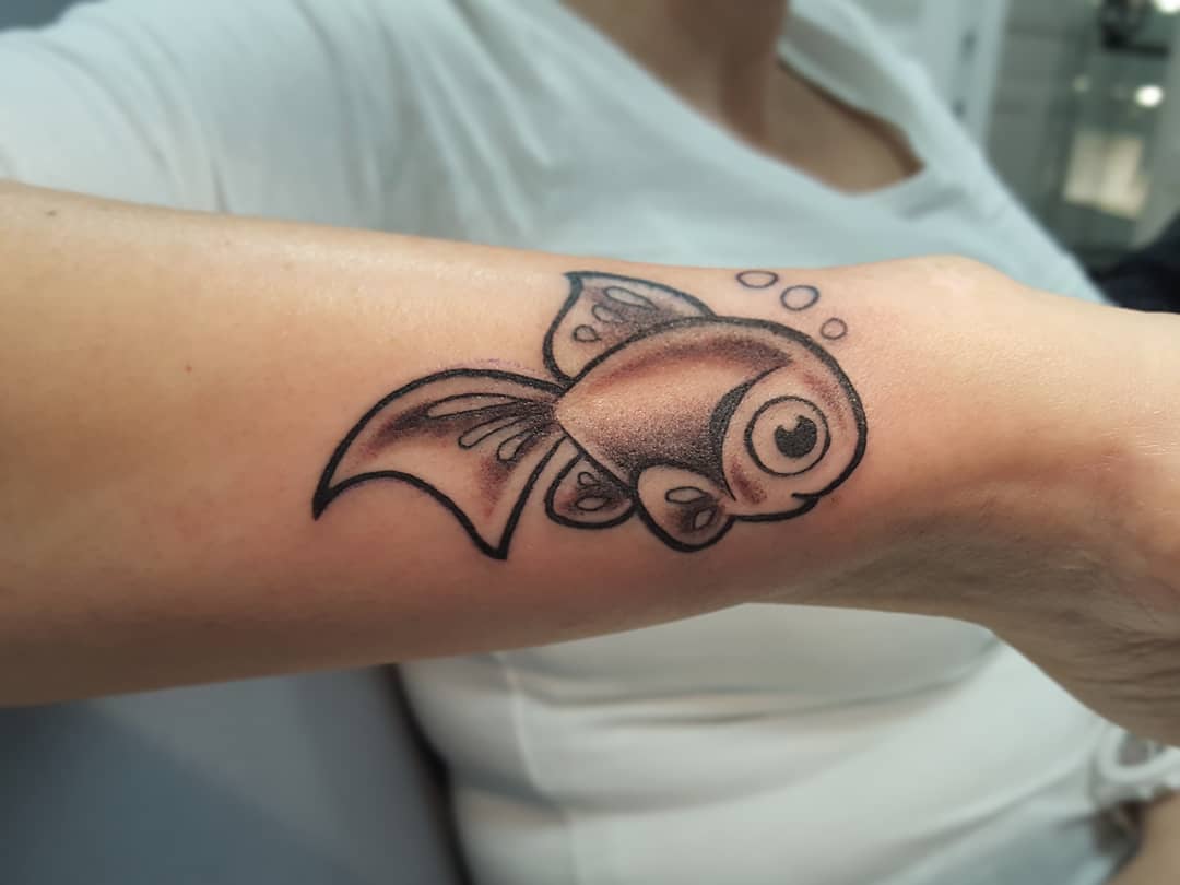 Fish cartoon tattoo on hand.