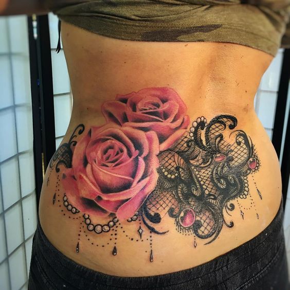 Girl with lace and rose tattoo on back.