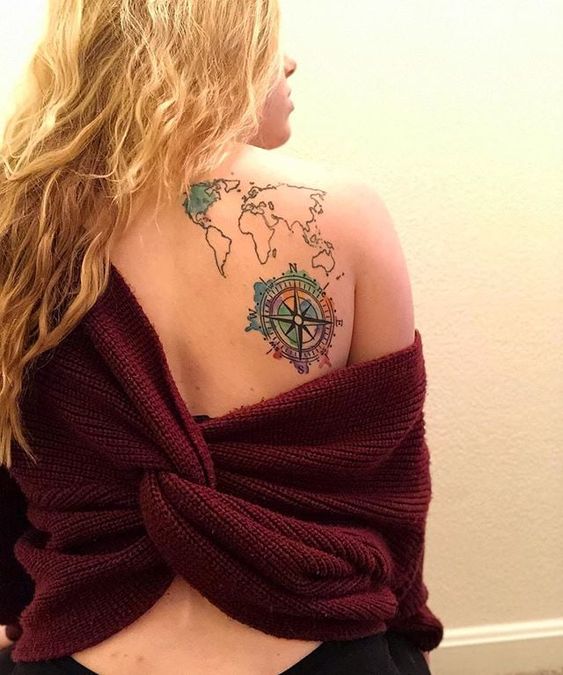 Impressive world map tattoo with compass on back shoulder.