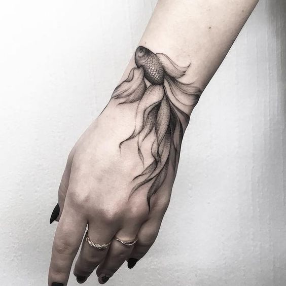 Incredible fish tattoo on hand.
