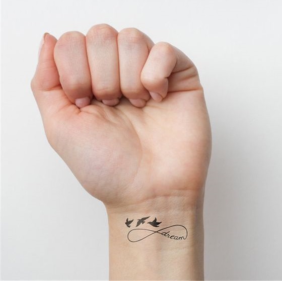 Infinity dream tattoo with birds on wrist.