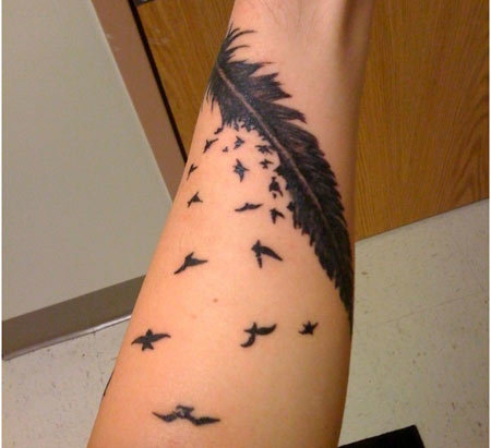 Little birds coming from feather inked on hand.